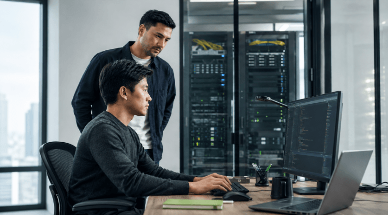 Drovix liquidity provider professionals at computers in a modern server room with data systems.
